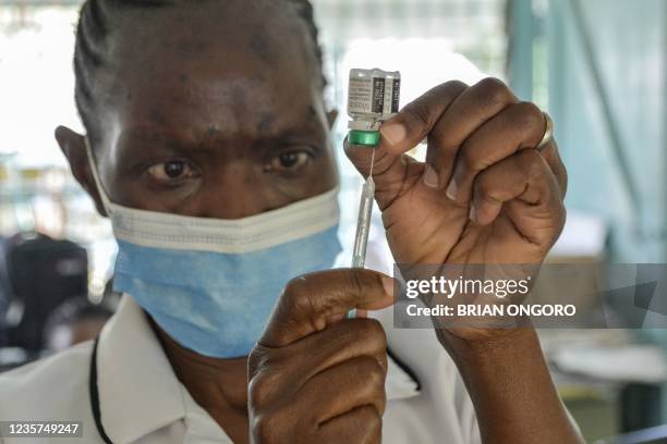 Health worker prepares a malaria vaccination for a child at Yala Sub-County hospital, in Yala, Kenya, on October 7, 2021. - World Health Organization...