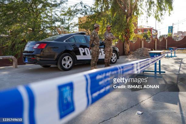 Members security forces stand by a police vehicle outside a school housing polling stations, a day before security forces vote in Iraq's northern...