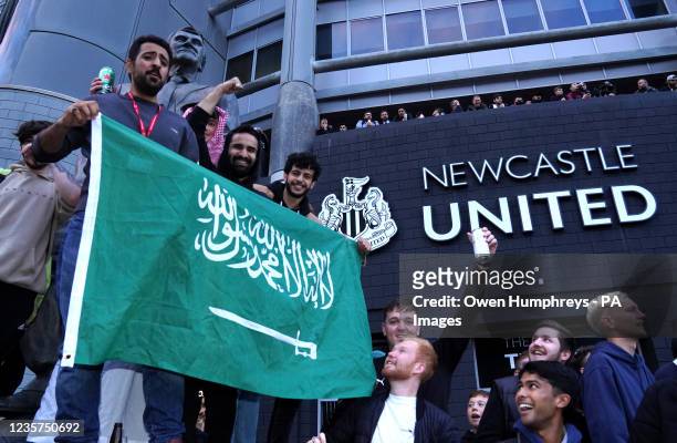 Newcastle United fans celebrate at St James' Park following the announcement that The Saudi-led takeover of Newcastle has been approved. Picture...