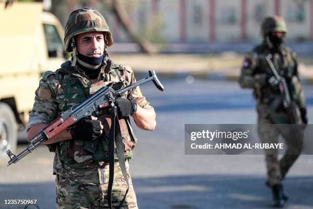 Members of Iraq's Hashed al-Shaabi paramilitary forces stand guard during an election rally for the "Asaib Ahl al-Haq" movement in the capital...
