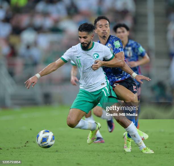 Saleh Al-Shehri of Saudi Arabia and Yuto Nagatomo of Japan tussle for the ball during the 2022 FIFA World Cup Qualifier match at King Abdullah Sports...
