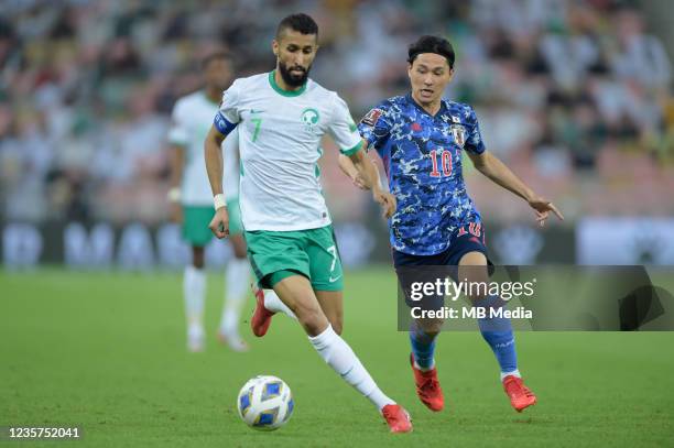 Salman Al-Faraj of Saudi Arabia and Takumi Minamino of Japan during the 2022 FIFA World Cup Qualifier match at King Abdullah Sports City on October...