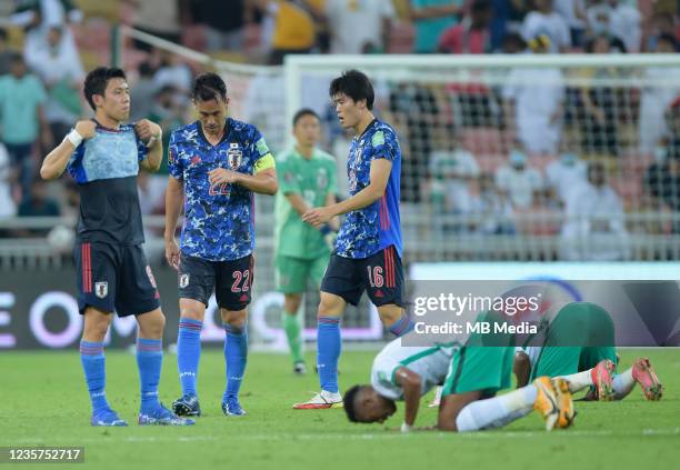 Wataru Endo, Maya Yoshida and Takehiro Tomiyasu of Japan show dejection as Saudi Arabia celebrate their win in the 2022 FIFA World Cup Qualifier...