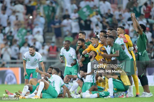Saudi Arabia players pose for a team picture after defeating Japan the 2022 FIFA World Cup Qualifier match at King Abdullah Sports City on October 7,...