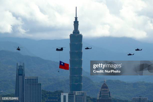 Military helicopters carrying tremendous Taiwan flags conduct a flyby rehearsal ahead of National Day celebration, near Taipei 101 , amid escalating...