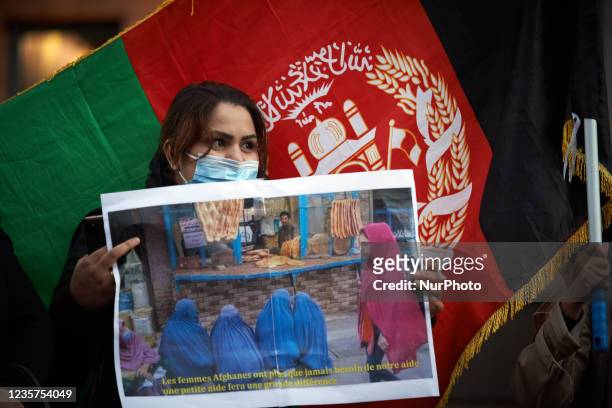 Woman from Afghansitan holds a placard depicting women under Taliban's rules. Dozens of people and members of the Afghani community of Toulouse...