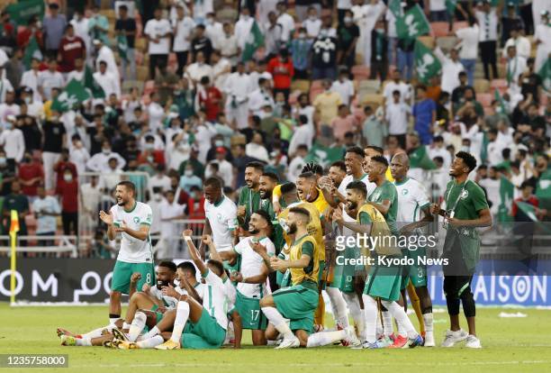 Saudi Arabia players celebrate after a 1-0 win against Japan in a Group B football match at King Abdullah Sports City Stadium in Jeddah, Saudi...