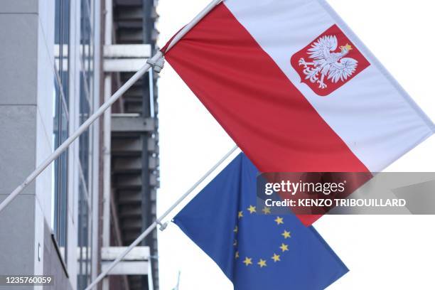 Picture taken on October 8, 2021 shows the polish flag and EU flag at the entrance of Polish embassy in Brussels. - Poland's Prime Minister on...