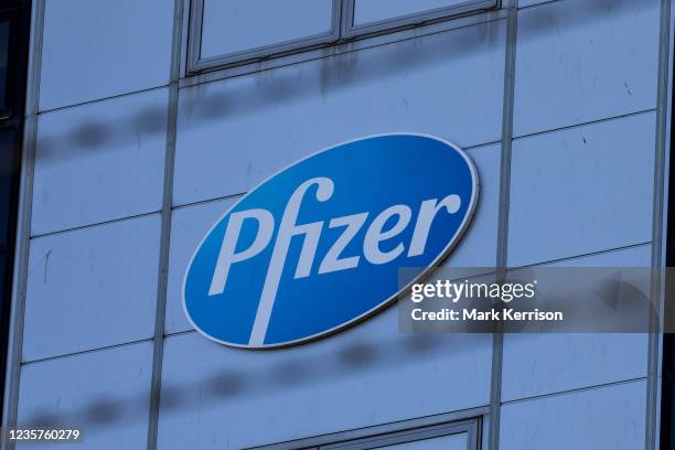 Pfizer sign is pictured through barbed wire outside the Pfizer plant in Discovery Park on 4th October 2021 in Sandwich, United Kingdom. Pfizer...