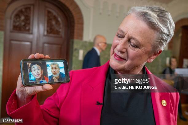 Berit Reiss-Andersen, chair of the Nobel Peace Prize Committee, presents a mobile phone displaying a combination of pictures of journalists Maria...