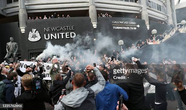 Newcastle United supporters celebrate outside the club's stadium St James' Park in Newcastle upon Tyne in northeast England on October 7 after the...