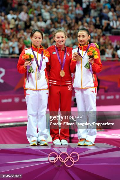 Gold medallist Rosie MacLennan of Canada on the podium alongside silver medallist Huang Shanshan and bronze medallist He Wenna, both of China after...