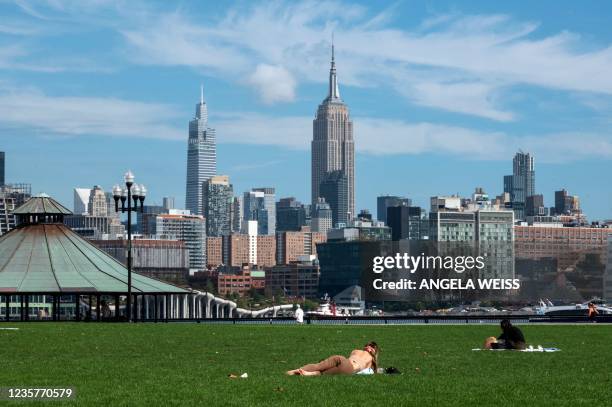 The Empire State Building is seen as people sunbathe on October 08, 2021 in Jersey City, New Jersey.