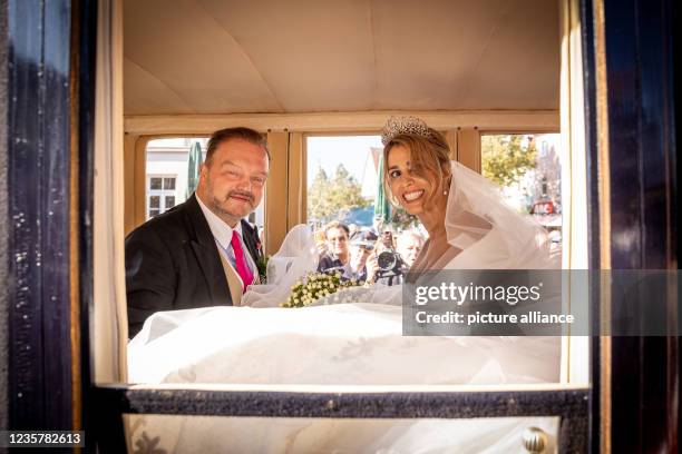 October 2021, Lower Saxony, Bückeburg: The groom, Prince Alexander zu Schaumburg-Lippe, and the bride, Princess Mahkameh zu Schaumburg-Lippe, sit in...