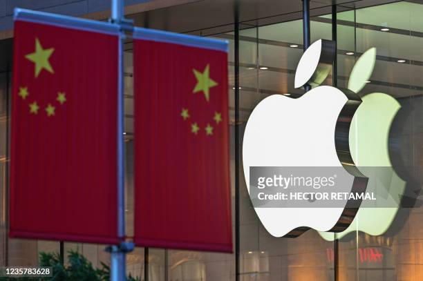 The Chinese national flag is displayed in front of an Apple store in Shanghai on October 9, 2021.