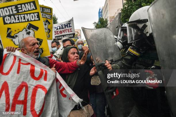 Protesters scuffle with riot police during an anti-racism rally in Athens on October 9, 2021. - Protesters are condemning the recent attacks on...