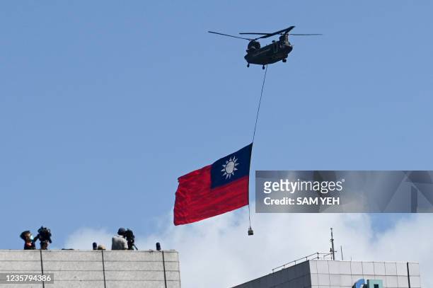 Chinook helicopter carries a Taiwan flag during national day celebrations in Taipei on October 10, 2021.