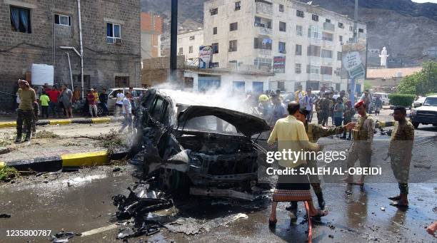 Yemeni security forces and onlookers gather at the scene of a car-bomb explosion in the heart of Yemen's southern port city of Aden, on October 10,...