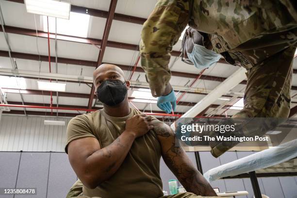 Preventative Medicine Services NCOIC Sergeant First Class Demetrius Roberson administers a COVID-19 vaccine to a soldier on September 9, 2021 in Fort...
