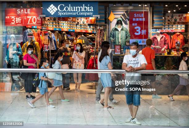 Shoppers walk past the American sportswear brand Columbia store in Hong Kong.