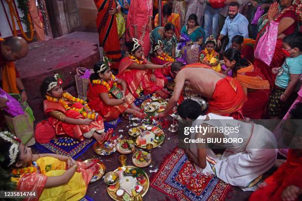 Hindu devotees offer prayers to girls dressed as Hindu goddess Durga for the 'Kumari' rituals during the Durga Puja festival at Kamakhya Temple in...