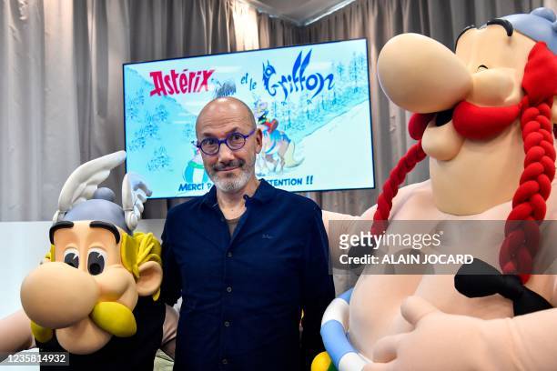 French writer and designer Jean-Yves Ferri poses between effigies of comic book characters Asterix and Obelix during the presentation of the new...