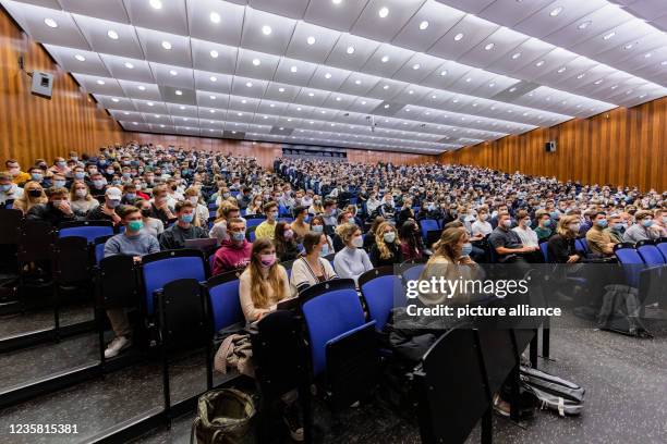 October 2021, North Rhine-Westphalia, Münster: Students wear mouth-to-nose coverings while sitting close to each other during the lecture "BWL 1" in...