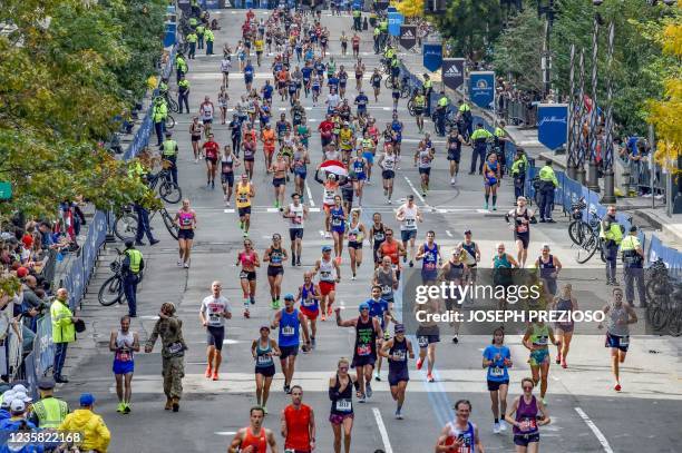 Runners make their way to the finish line down Boylston Street during the 125th Boston Marathon in Boston, Massachusetts on October 11, 2021.