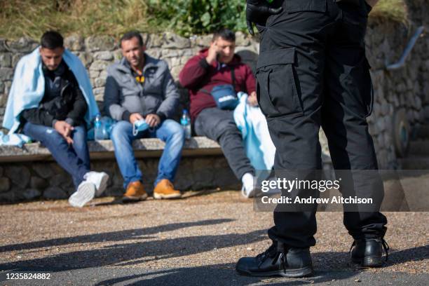 Coast Guard staff help asylum seekers who have spent all night travelling by dinghy from France to the UK, landing on the beach in Folkestone, United...