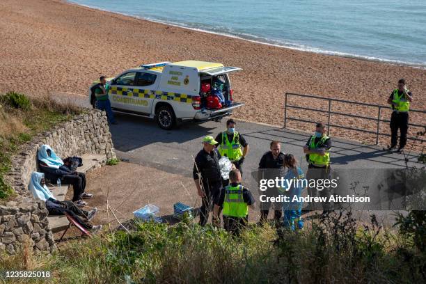 Coast Guard staff and local police help asylum seekers who have spent all night travelling by dinghy from France to the UK, landing on the beach in...