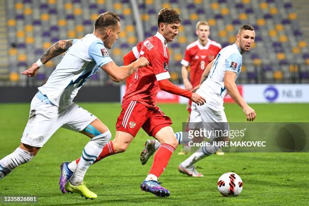 Russias Aleksei Miranchuk vies for the ball with Slovenias Jure Balkovec and Jasmin Kurtic during the FIFA World Cup Qatar 2022 qualification Group H...