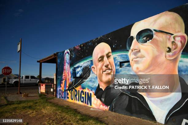 Pickup truck drives past a mural of billionaire Amazon founder Jeff Bezos and his brother Mark Bezos with a Blue Origin rocket in Van Horn, Texas on...