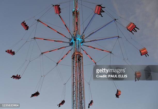 Visitors enjoy a ride at the Hull Fair on October 11, 2021. - The Hull Fair, one of Europe's largest travelling fairs, returned after a break due to...