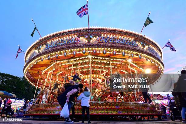 Visitors enjoy a carousel ride at the Hull Fair on October 11, 2021. - The Hull Fair, one of Europe's largest travelling fairs, returned after a...