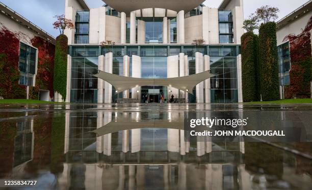 The chancellery's facade is reflected in a puddle before the arrival of Italy's President in Berlin on October 12, 2021.