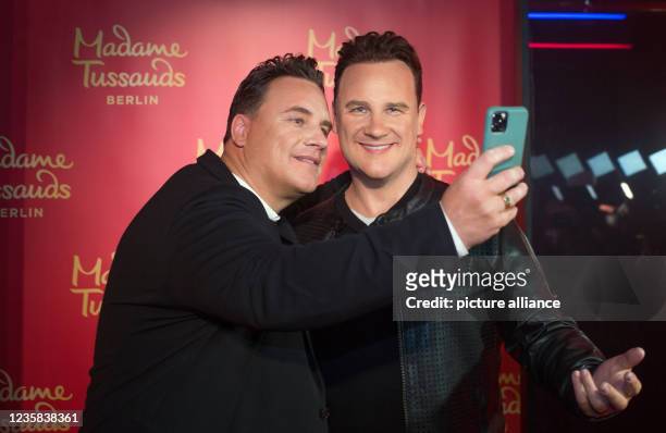 August 2021, Berlin: TV presenter and fashion designer Guido Maria Kretschmer photographs himself and his own figure in wax at the Madame Tussauds...