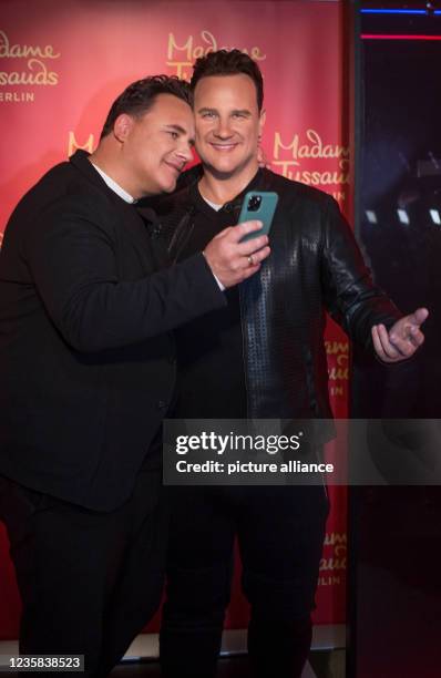 August 2021, Berlin: TV presenter and fashion designer Guido Maria Kretschmer photographs himself and his own figure in wax at the Madame Tussauds...