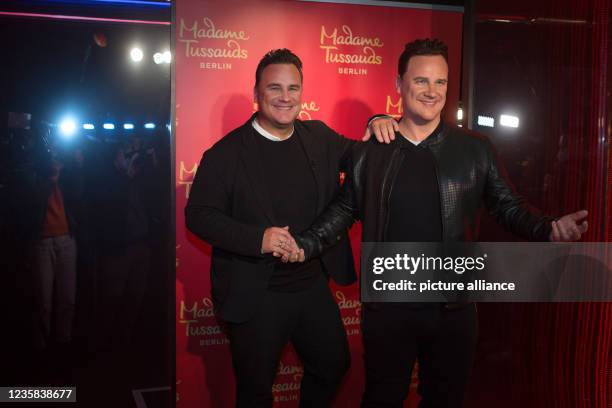 August 2021, Berlin: TV presenter and fashion designer Guido Maria Kretschmer stands next to his own figure in wax at the Madame Tussauds wax museum...