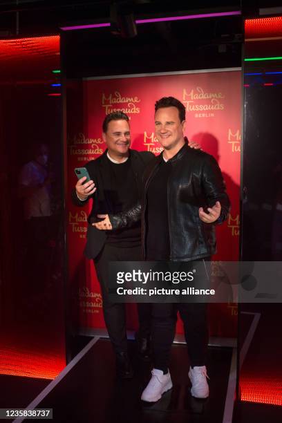 August 2021, Berlin: TV presenter and fashion designer Guido Maria Kretschmer stands next to his own figure in wax at the Madame Tussauds wax museum...