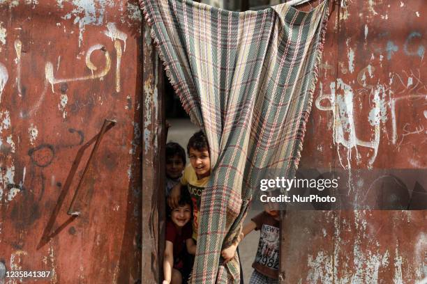 Palestinian children play next to their home in the Gaza Strip's al-Shati refugee camp in Gaza City on October 12, 2021.