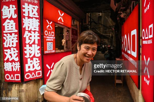 This photo taken on October 12, 2021 shows a customer surnamed Yang at a small shop buying dalgonas, a crisp sugar candy featured in the Netflix...