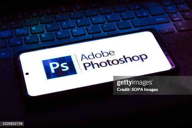 In this photo illustration the Adobe Photoshop logo seen displayed on a smartphone on the background of a pc keyboard.