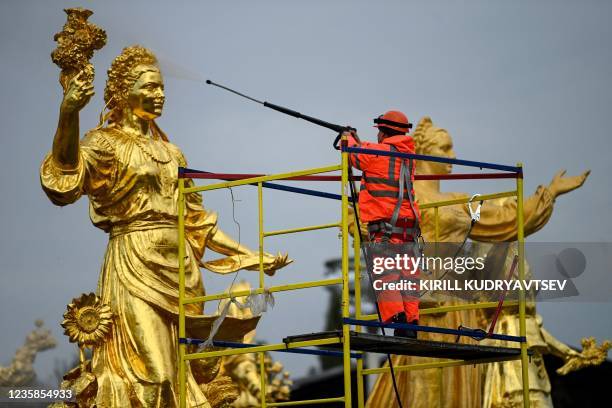 Municipal worker cleans the Druzhba Narodov fountain at the All-Russia Exhibition Centre as part of the city's preparations for winter in Moscow on...