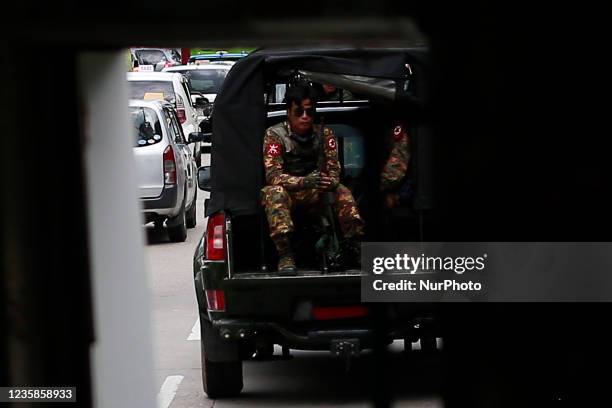 Armed soldiers in a military vehicle patrol the street in Yangon, Myanmar on October 13, 2021.