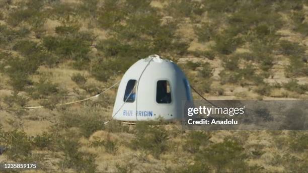 Screenshot taken from a live handout video on October 13, 2021 shows Blue Origin's New Shepard crew capsule lands in Texas, the United States....