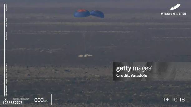 Screenshot taken from a live handout video on October 13, 2021 shows Blue Origin's New Shepard crew capsule lands in Texas, the United States....