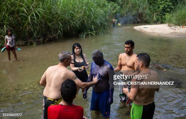 Man is painted in blue during a ritual in the Yaracuy river on the Sorte mountain in Yaracuy state, Venezuela, on October 11, 2021. - On October,...