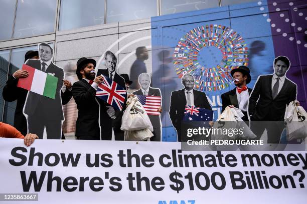 Activists dressed as "debt collectors" hold cutouts of the leaders of Italy, Mario Draghi, United Kingdom, Boris Johnson, United States, Joe Biden,...