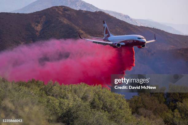 Firefighting jet drops fire retardant at the Alisal Fire on October 13, 2021 near Goleta, California. Pushed by high winds, the fire grew to 6,000...