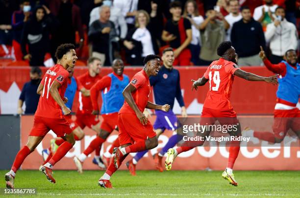 Tajon Buchanan and Jonathan David of Canada celebrate with Alphonso Davies after Davies scores a goal in the second half during a 2022 World Cup...